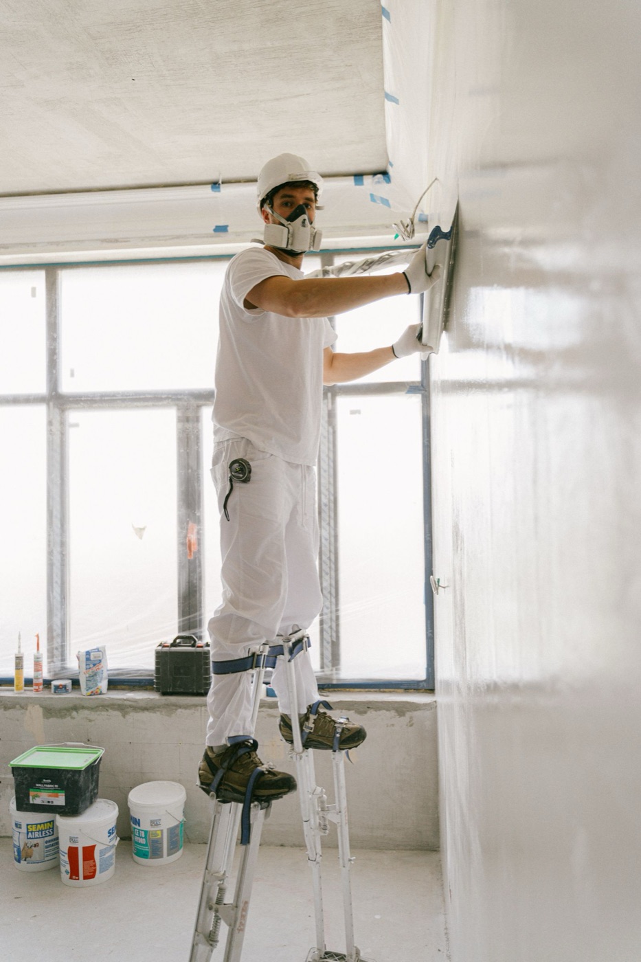 Installer hanging a sheet of drywall on a wall